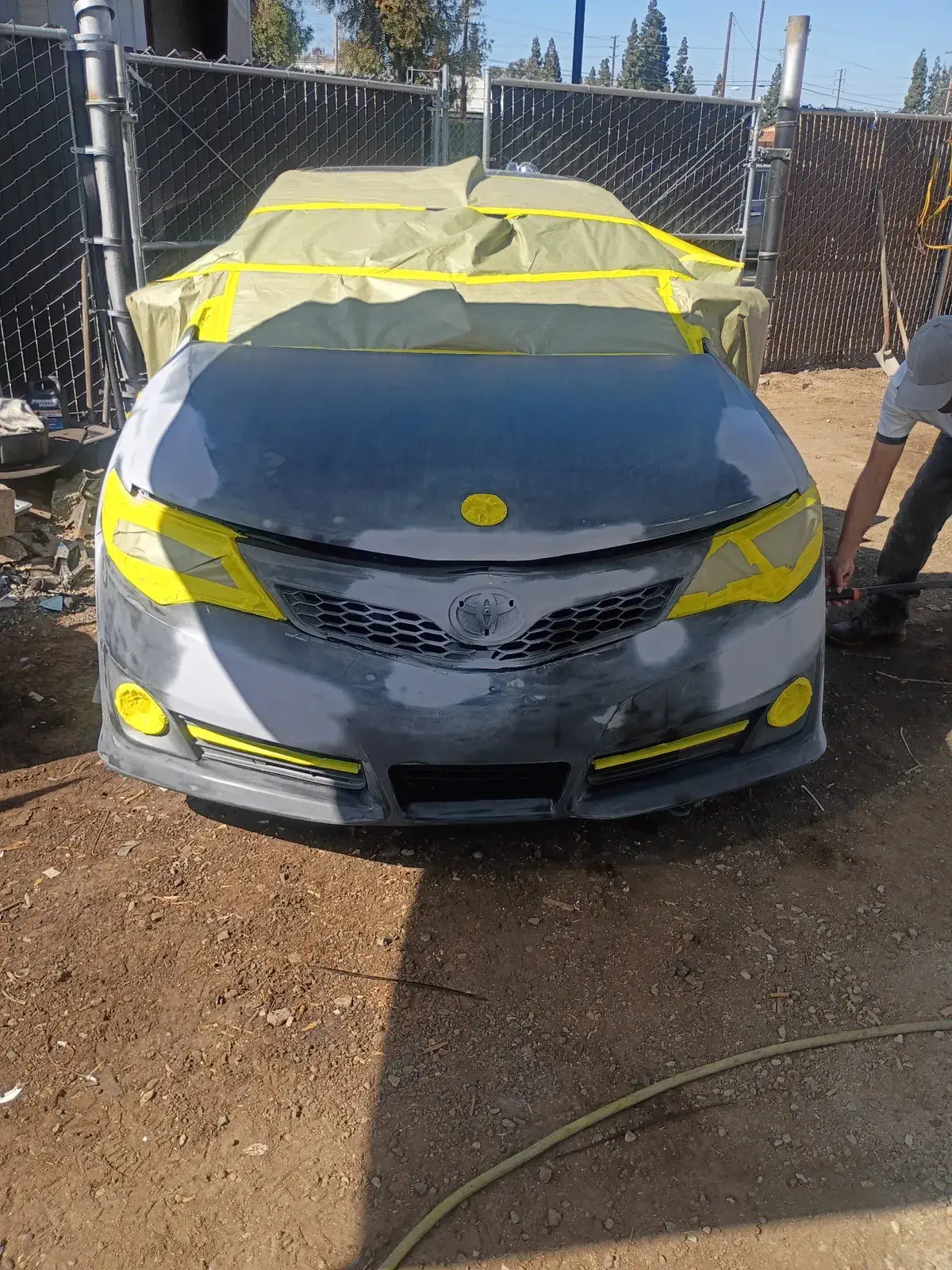 Black Toyota Camry with front end damage before collision repair